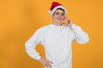 young teenage man with santa claus hat isolated on color background