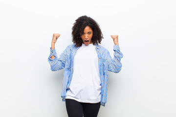 young cool african american woman shouting aggressively with an angry expression or with fists...