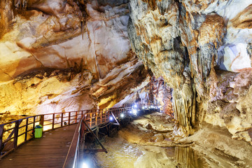 Wooden walkway among beautiful stalactites inside Paradise Cave