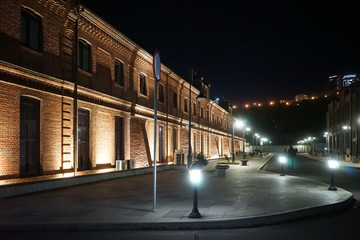 Naklejka na ściany i meble Night cityscape with brick buildings in the light of lanterns.