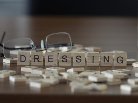 The concept of dressing represented by wooden letter tiles