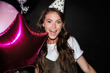 Image of young excited woman holding balloons and smiling