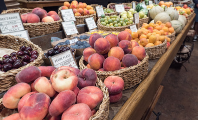 market stand with many different fruit and labels with names and prices in French