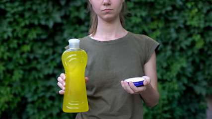 Woman choosing between chemical detergents and soda, environment protection