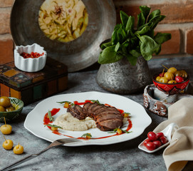 beef steak slices served with mashed potato in plate garnished with red sauce
