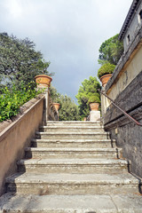 Fototapeta premium Beautiful scene with straight ancient stone stair going upwards in an old Italian park