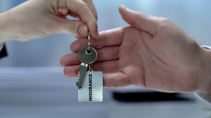 Female customer taking keychain from insurance agent, health protection, care