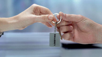 Lady taking keys from hand, using power to influence, illegal lobbying interests