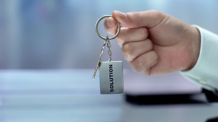 Solution word on keychain hand showing to camera, accepting opportunity, startup