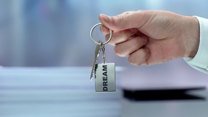 Dream word on keychain hand showing to camera, key to future, motivation