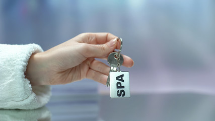 SPA written on keychain customer holding in hand, wellbeing and healthcare rest