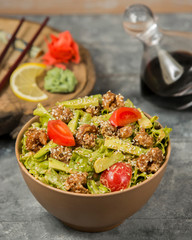 fried chicken salad with fresh avocado, lettuce, tomato in oil garnished with sesame