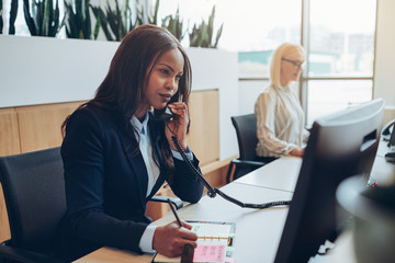 African American businesswoman taking a telephone message in an