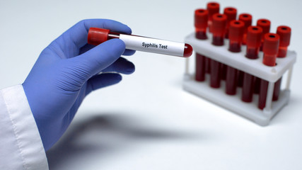 Syphilis test, doctor showing blood sample in tube, lab research, health checkup