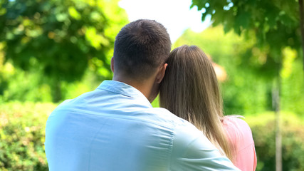 Man tenderly hugging girlfriend, couple enjoying park view, love closeness