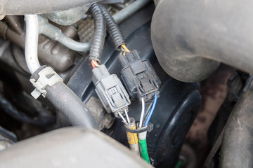 Wires under the open hood of a car engine. Car diagnostics and repair at a service station
