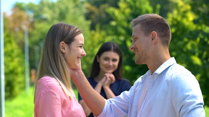 Obraz premium Cheerful man and woman smiling each other, happy friend on background, love