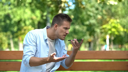 Man angrily talking phone loudspeaker, relations conflict, misunderstanding