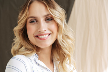 Image of pleased elegant blonde woman smiling at camera