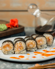 nori sushi rolls with shrimp garnished with sweet chili sauce