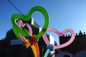 Palloncini colorati a forma di cuore contro il cielo azzurro di primavera