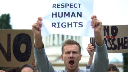 Crowd shouting slogan to respect human rights, no harassment, against violence