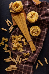 Fototapeta na wymiar assortment of pasta on dark stone background Copy space