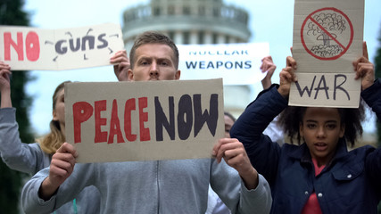 Activists waving banners protesting against mass shootings, nuclear weapon, war