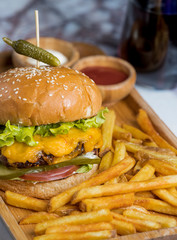 close up of beef burger served with french fries and sauce