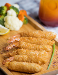 close up of crispy fried shrimps served with boiled vegetables