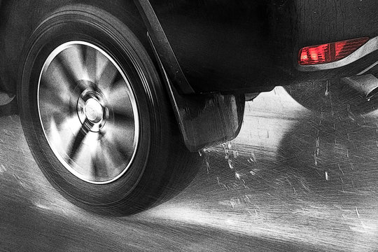 The Detail of the rear wheel of a car driving in the rain on a wet road. Aquaplaning in road traffic.