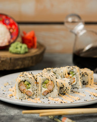 close up of sushi rolls with shrimp and cucumber garnished with spicy sauce