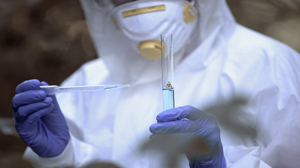 Exclusion zone researcher analyzing water sample, biological hazard, experiment