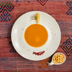 top view of lentil soup served with bread stuffing and lemon