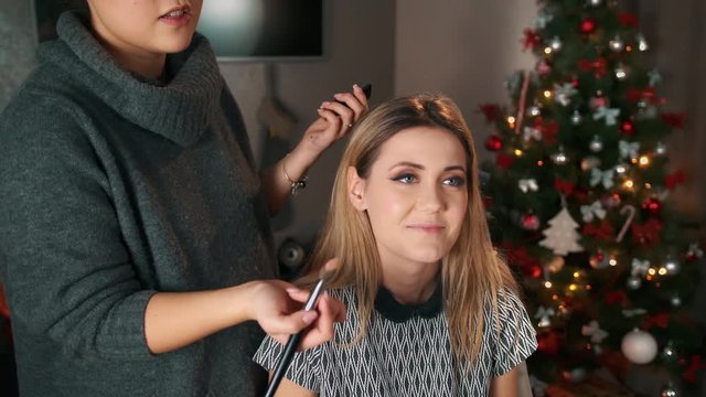 Asian make-up artist makes excuses to a dissatisfied customer. Apply blush with a big brush.