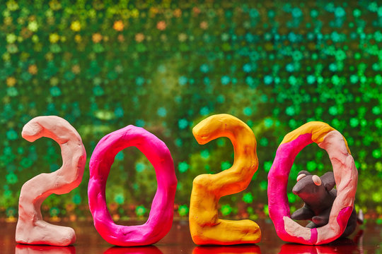 2020 New year design concept with the symbol of the year rat. Colored figures of plasticine on a green background