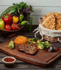 grilled beef steak served with bulgur, boiled and grilled vegetables