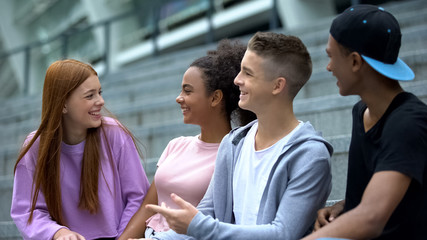 Cheerful teenagers having fun together, happy multiracial friends, communication
