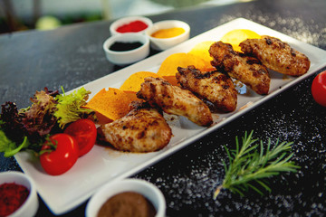 grilled chicken wings served with chips, tomato and lettuce
