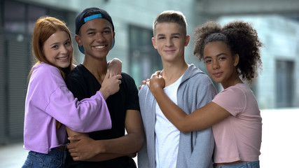 Hugging teen couples smiling at camera, first relationship, friendship closeness