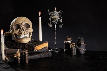 Realistic model of a human skull with teeth on a wooden dark table, black background. Medical...