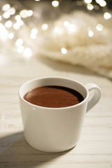 White ceramic cup of hot cocoa on white wooden background