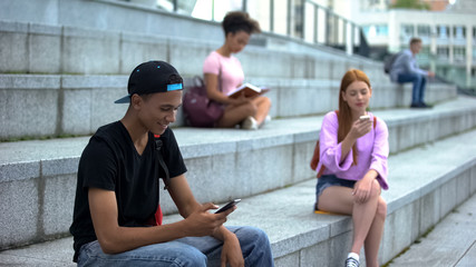 Black university student scrolling smartphone, social networks, gadget addiction