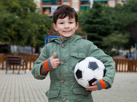 boy holding soccer ball outdoors