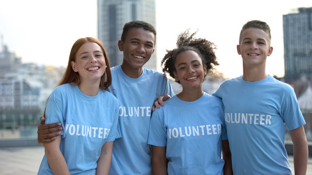 Happy young people volunteer t-shirts posing camera, social teamwork, help