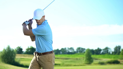 Professional male player hitting ball during golf competition, sport and hobby