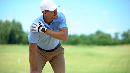 Young male golf player suffering terrible shoulder spasm after shot, trauma