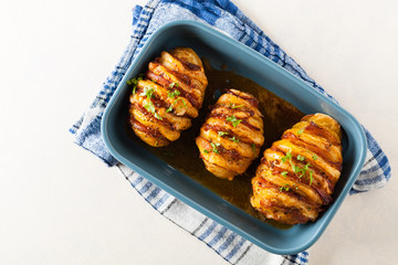 Baked potatoes in Swedish. Hasselback. Stuffed with cheese and bacon. Top view.