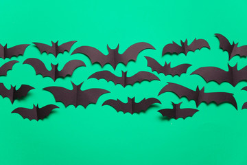 Fototapeta na wymiar Halloween paper vampire bat decorations on a green background.