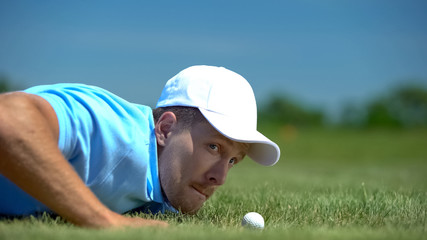 Tricky man blowing golf ball in hole, agility and cunning success strategy hobby
